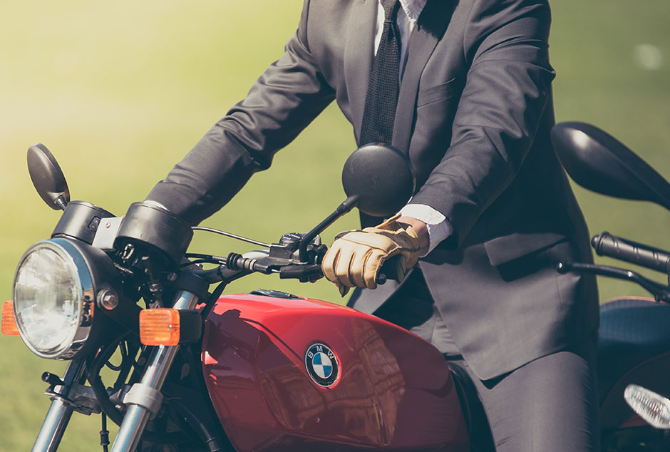 A photograph of a businessman riding a classic motorcycle